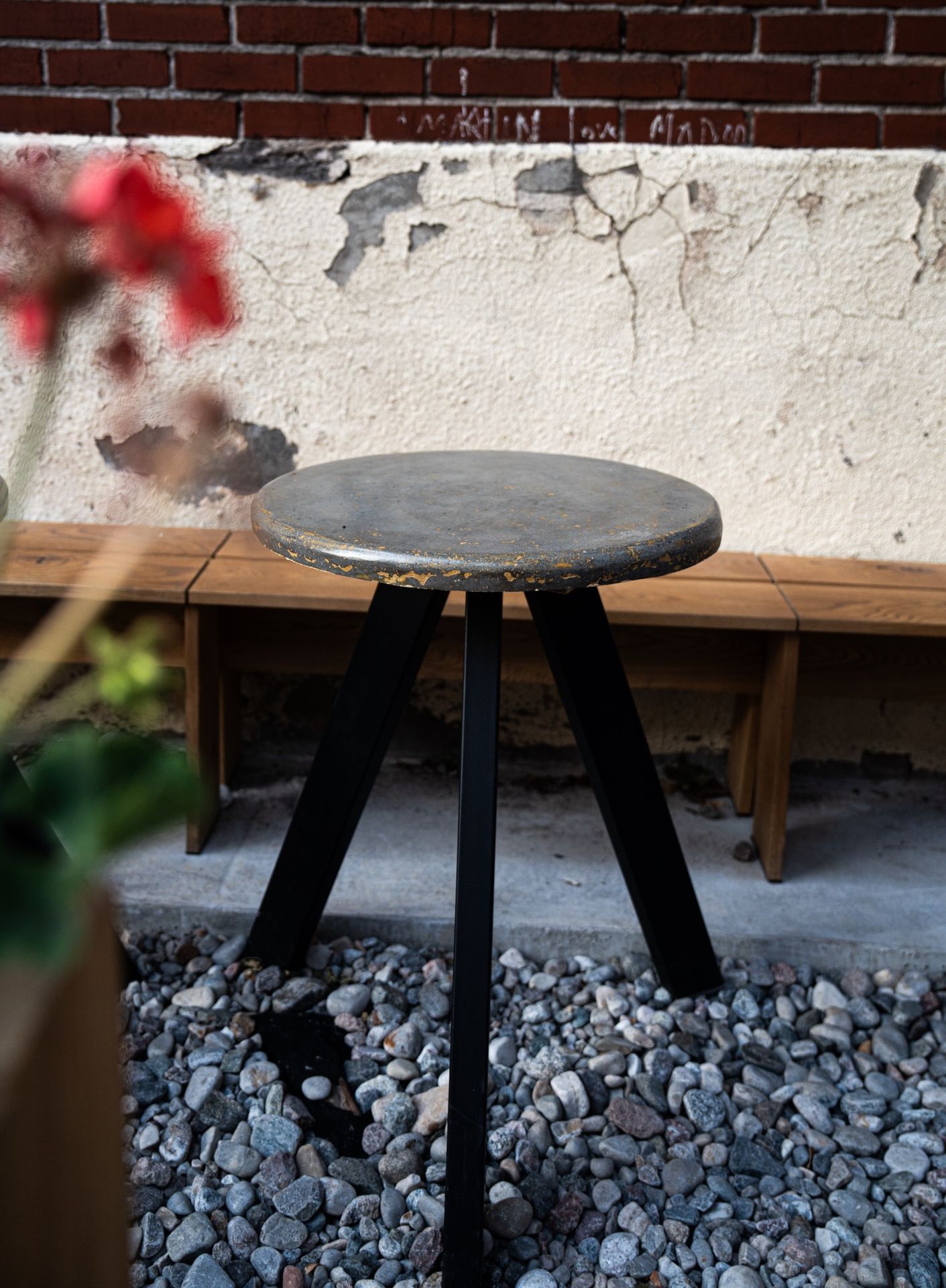 détail table béton ronde avec base noire tripode